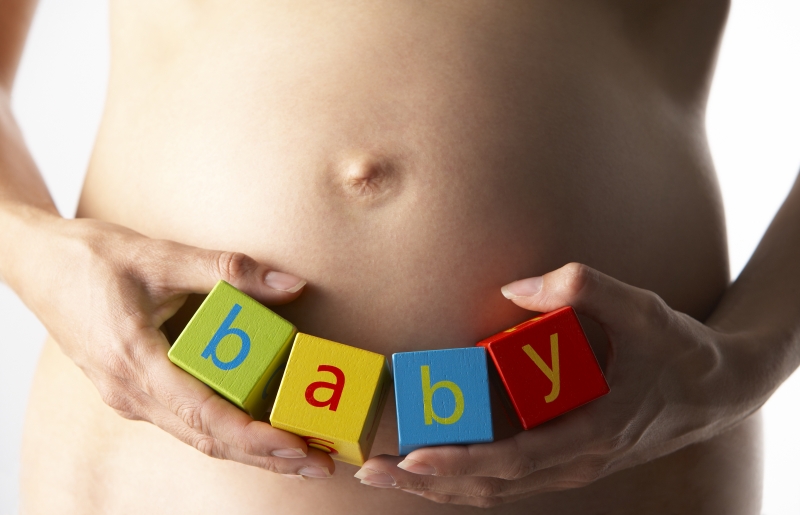 2173754-pregnant-woman-holding-blocks-spelling-baby
